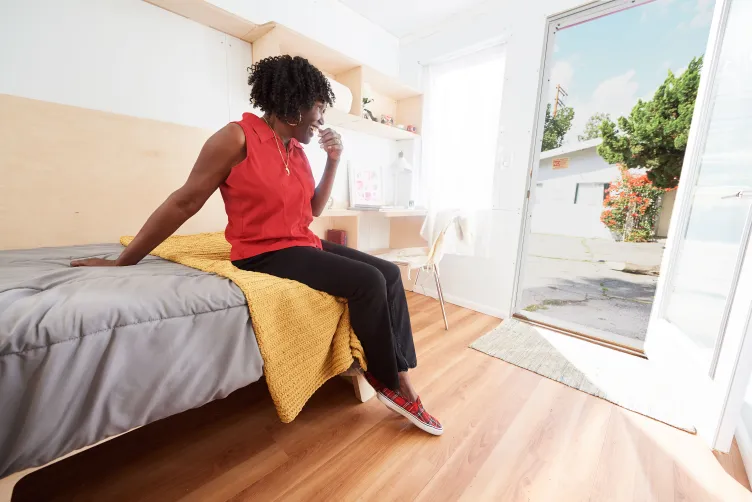 Kathy Huck, a full-time volunteer for Hope of the Valley, sits inside a prototype Homes for Hope unit.